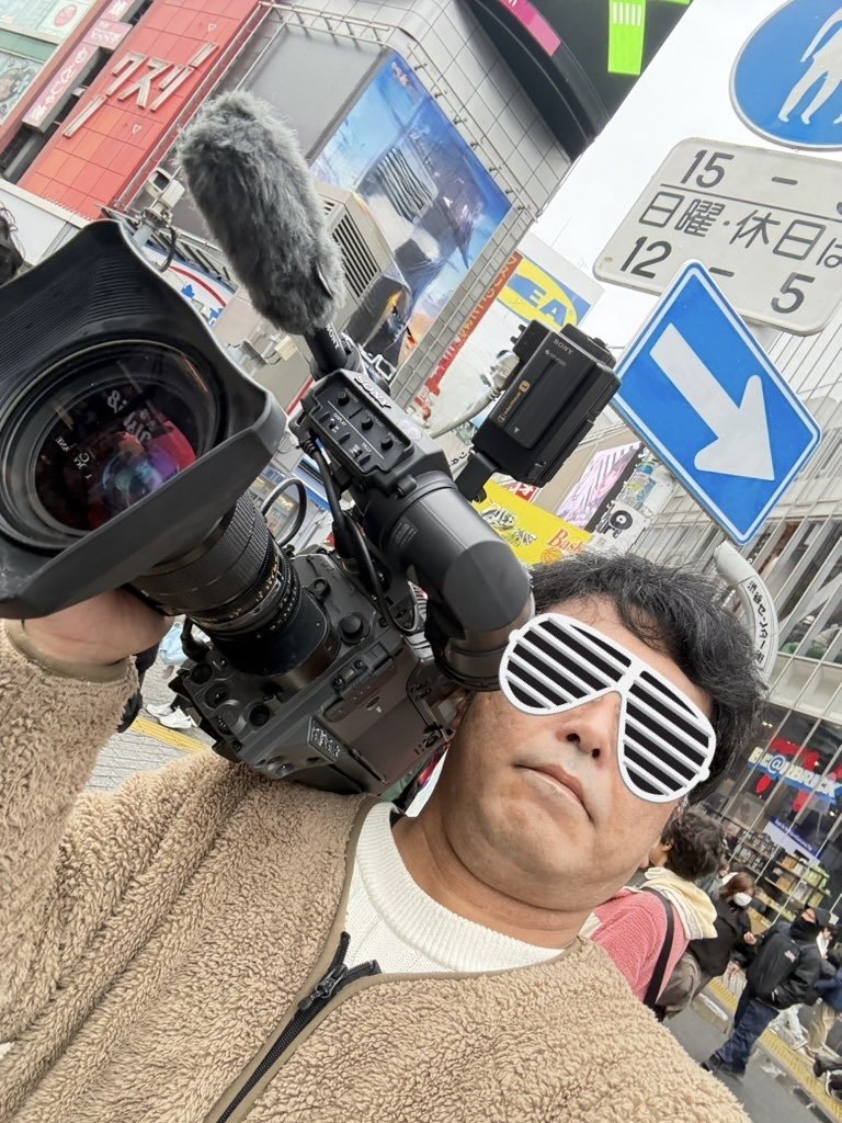 KOTOKU PRODUCTION 代表 古徳啓吾が秋葉原で業務用ショルダーカメラを構えている写真